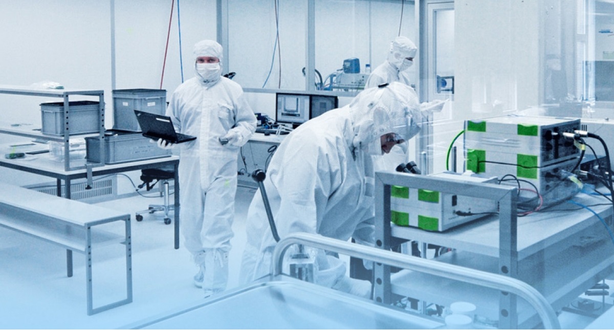 Laboratory specialists working in a controlled cleanroom